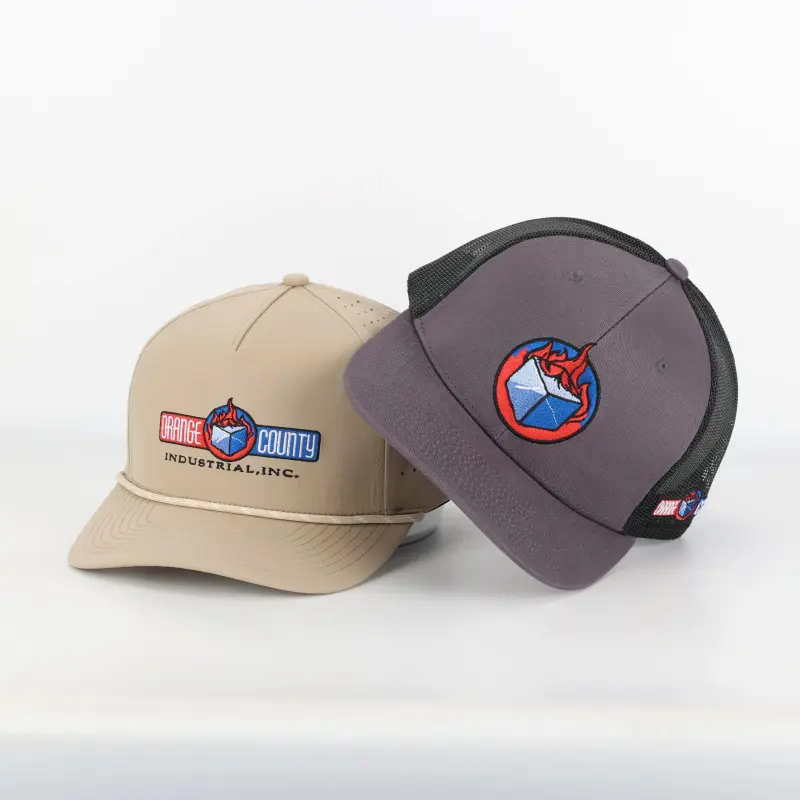 A khaki rope cap and a charcoal mesh-back trucker, both carrying the Orange County Industrial logo