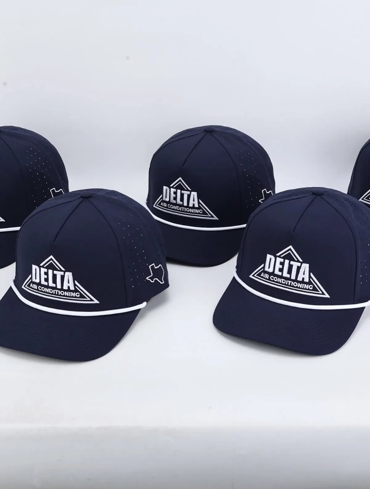 Navy Delta Air Conditioning 5-panel caps with embroidered logo and a white Texas outline on the side panel