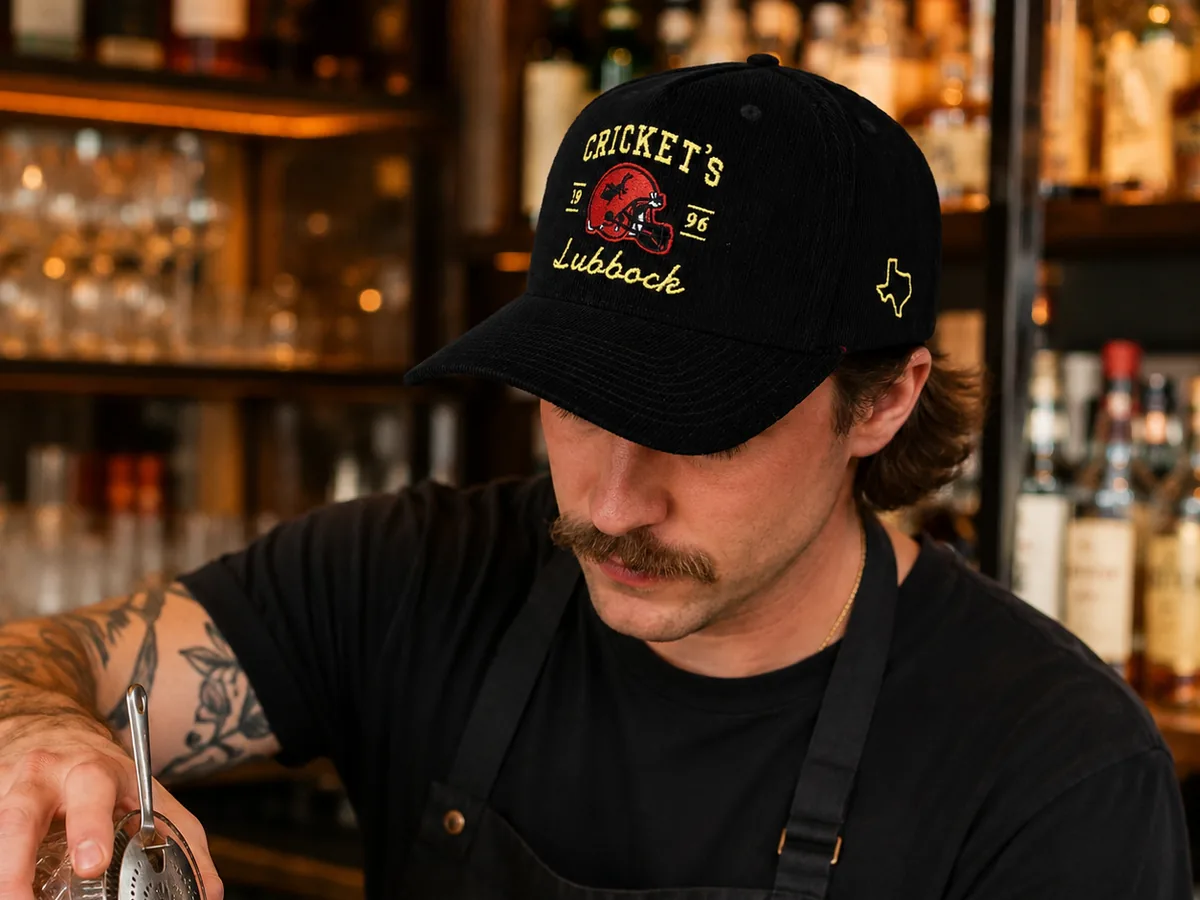 Bartender wearing a black corduroy Reel48 cap with custom embroidery